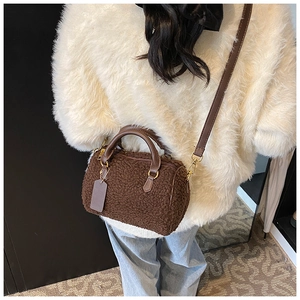 Detail of dark brown plush fleece boston bag worn with a casual autumn beige sweater