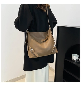 Close-up of brown litchi pattern leather tote bag with silver buckle strap detail
