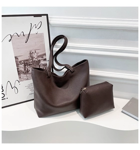 Detail of dark brown leather tote bag with pebble texture and matching pouch insert