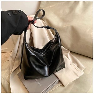 Detail of adjustable metal buckle strap on a black glossy large capacity hobo shoulder bag