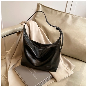 Detail of glossy black large Hobo bag with adjustable strap and metallic logo plaque
