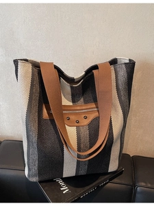 Large striped canvas tote bag with brown straps and leather zip pocket detail