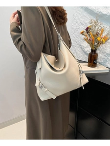 Fashionable cream tote bag with lychee texture and adjustable strap on a female model