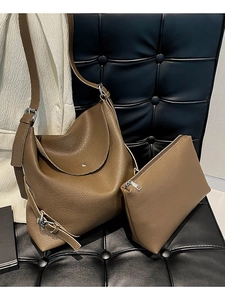 Dark brown leather hobo shoulder bag set with silver hardware on a leather chair
