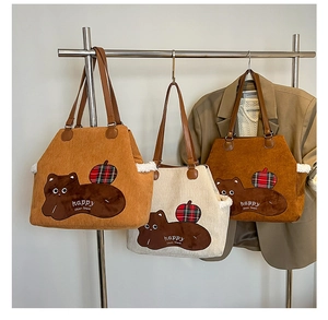 Detail of corduroy tote bags with cute animal embroidery and brown leather handles