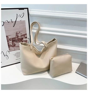 Detail of beige faux leather tote set with pebble texture and matching zipper pouch