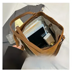 Interior detail of large brown corduroy tote bag showing large capacity for tablets and books