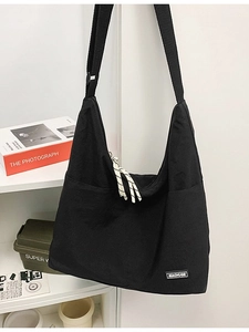 Minimalist black canvas hobo bag with adjustable wide strap for daily commute use