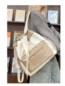 Close-up of beige and brown contrast canvas tote bag with adjustable shoulder strap