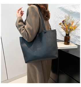 Detail of black pebbled leather tote bag showing large capacity and soft texture