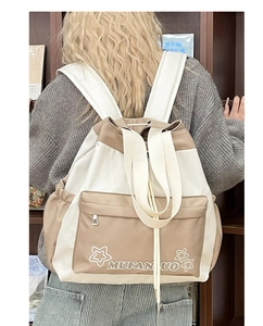 Detail view of khaki and cream colorblock canvas backpack with drawstring closure