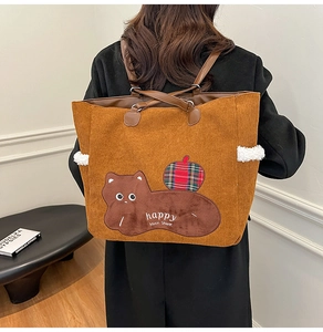 Brown corduroy tote bag with cat embroidery shown in a lifestyle back view setting