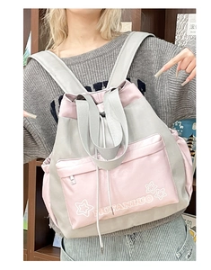 Close-up of a stylish grey and pink patchwork backpack with star logo and drawstring