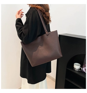 Side view of large dark brown leather tote bag worn by model for casual style