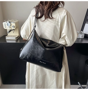 Close-up of black PU leather tote bag with Muon SharK logo and smooth metal zipper