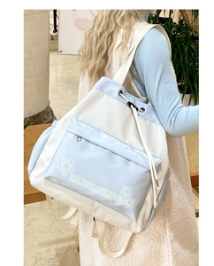 Detail of blue and white canvas backpack with drawstring closure and star embroidery