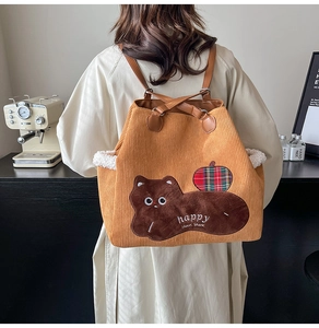 Corduroy tote backpack with cat embroidery and lamb wool trim detail on a model