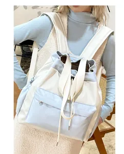 Detail view of the drawstring closure and padded shoulder straps on the blue nylon backpack