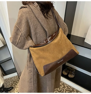 Close-up of brown suede patchwork tote bag with silver metallic twist lock and logo detail