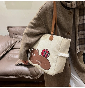 Close-up of corduroy tote bag featuring cute animal embroidery and fuzzy sheepskin trim