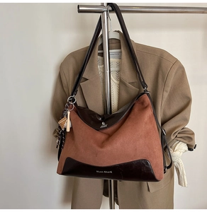 Detail of large tote bag showing brown suede and smooth leather texture with logo