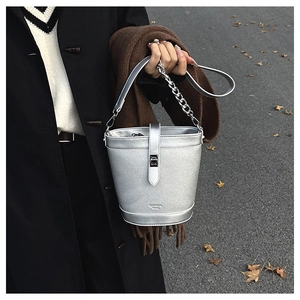 Detail of silver bucket bag showing litchi leather texture and chunky metal chain