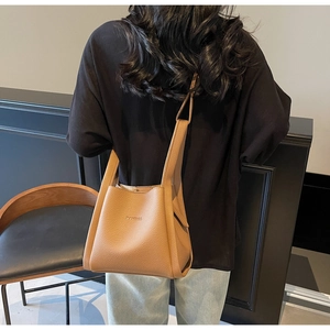 Close-up of khaki bucket bag with lychee texture and FANTROO logo being worn by model