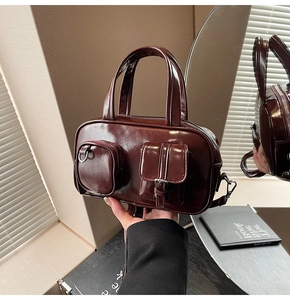 Macro detail of wine red glossy leather handbag with double pockets and smooth texture