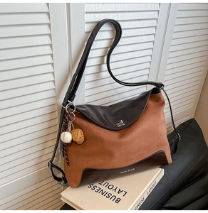 Detail of a contrast stitching tote bag with baseball charm and silver twist lock closure