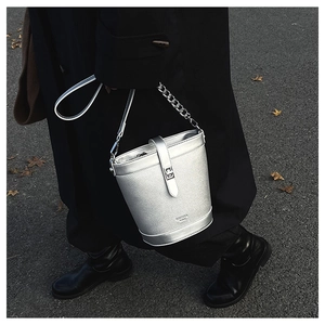 Close-up of silver bucket bag with pebble leather texture and metallic clasp closure