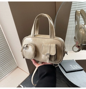 Detail of khaki PU leather bag featuring unique front pockets and glossy retro finish
