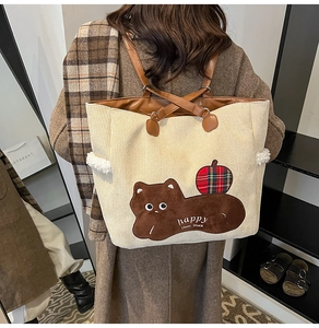 Detail of corduroy tote bag with cute animal embroidery and brown leather shoulder straps