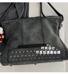 Close-up of matte charcoal tote bag showing rivet details and hidden zipper pocket