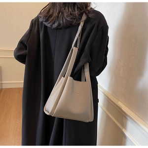 Detail of grey lychee leather bucket bag showing adjustable strap and FAMIRCO logo