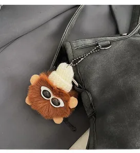 Plush brown bear charm with white knit hat and sunglasses attached to a black tote bag