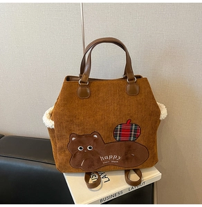 Close-up of brown corduroy tote bag featuring cat embroidery and soft plush side trim