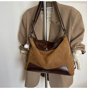 Detail of the suede and leather patchwork tote bag with baseball charm and brand logo