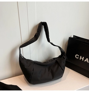 Detail of black nylon crescent bag with wide padded shoulder strap and zipper closure