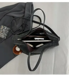 Internal view of a black tote bag showing spacious compartments and zipper storage pockets
