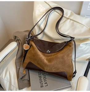 Detail of contrast stitching and silver twist-lock on a brown leather tote bag