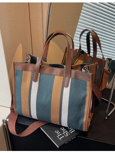 Large color-block canvas tote bag with brown leather trim and wide adjustable shoulder strap