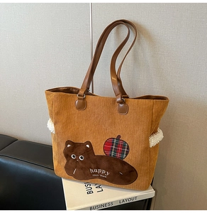 Detail of corduroy tote bag with cat embroidery and premium leather shoulder straps
