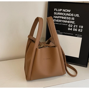 Detail of brown pebbled leather bucket bag with dual handles and HAMIROO logo