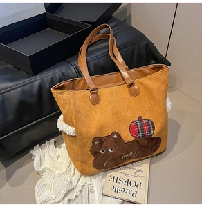 Detail of corduroy tote bag featuring cat embroidery and soft faux fur side panels
