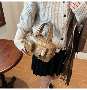 Brown vintage PU leather handbag with front pockets shown on model with white cardigan