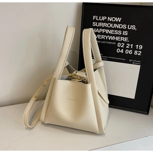 Detailed close-up of cream litchi grain leather texture and metallic strap hardware