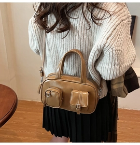 Detail view of the multiple pockets and smooth PU leather texture on the brown handbag