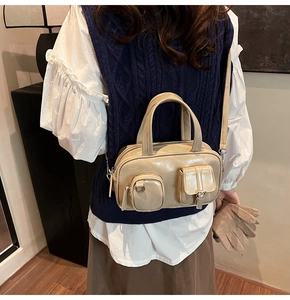 Close-up of beige leather bowling bag with functional pockets and silver hardware