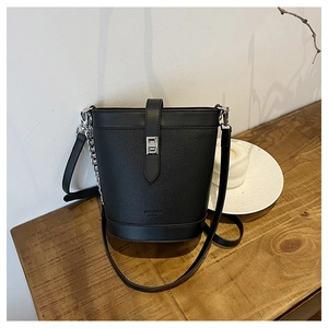 Detail of black bucket bag showing pebbled leather texture and silver twist lock closure