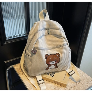 Detail view of corduroy backpack with cute bear embroidery and matching bear zipper charm